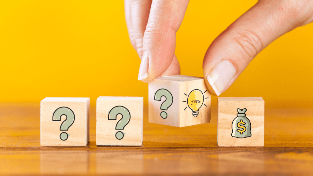 An image showing blocks with question marks and lightbulbs with a hand turning them