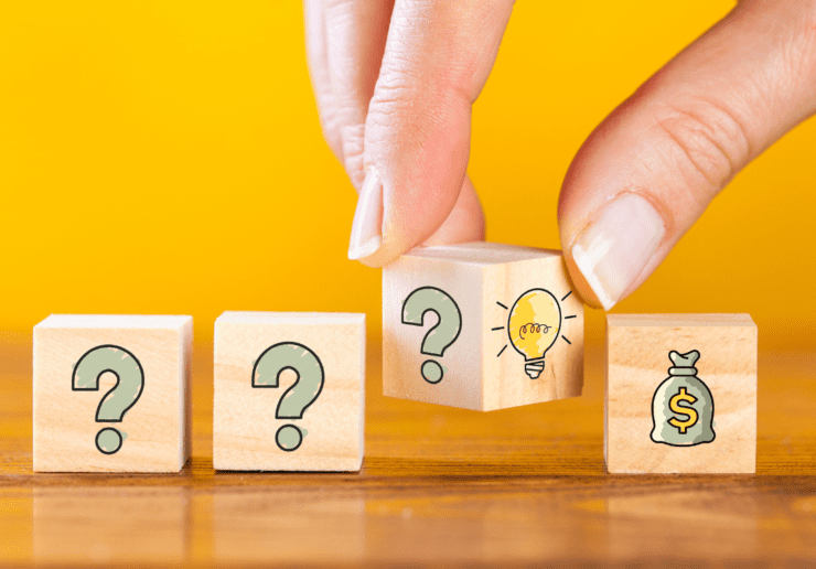 An image showing blocks with question marks and lightbulbs with a hand turning them
