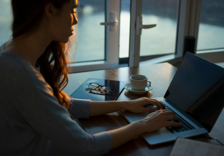 woman sitting beside table using laptop